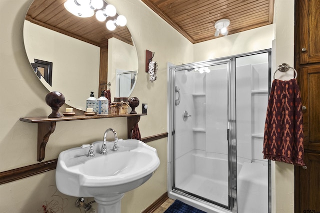 bathroom featuring sink, wood ceiling, and a shower with door