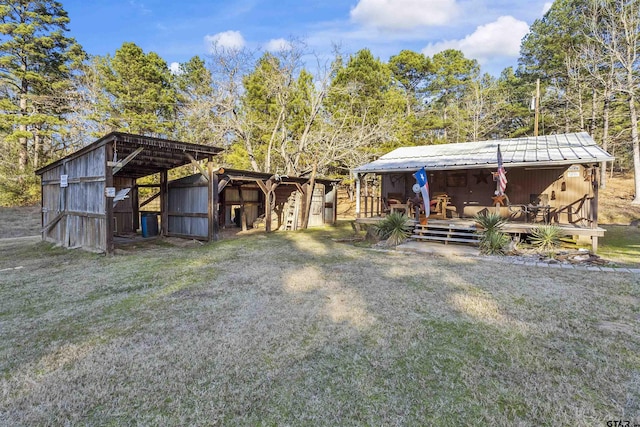 view of front of house featuring an outdoor structure and a front yard