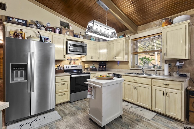 kitchen with hardwood / wood-style floors, a kitchen island, stainless steel appliances, sink, and lofted ceiling with beams