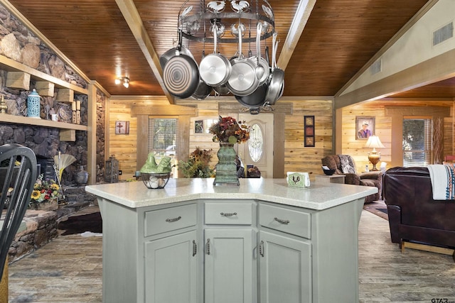 kitchen featuring lofted ceiling, wood ceiling, wooden walls, and a center island