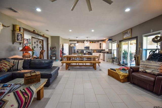 living area with ceiling fan, visible vents, and recessed lighting