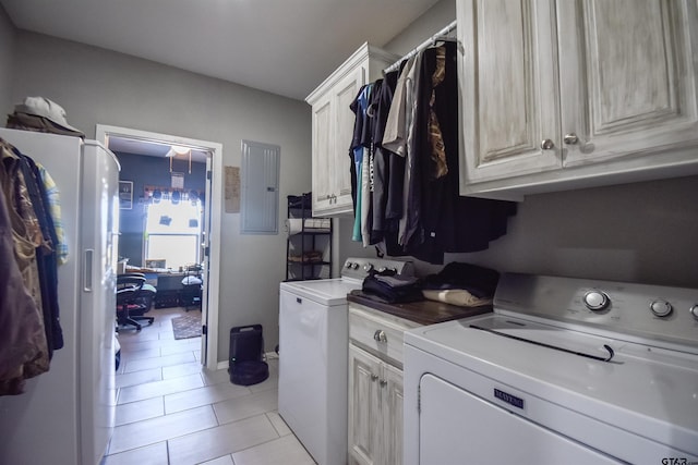 clothes washing area with cabinet space, light tile patterned floors, electric panel, and washer and clothes dryer