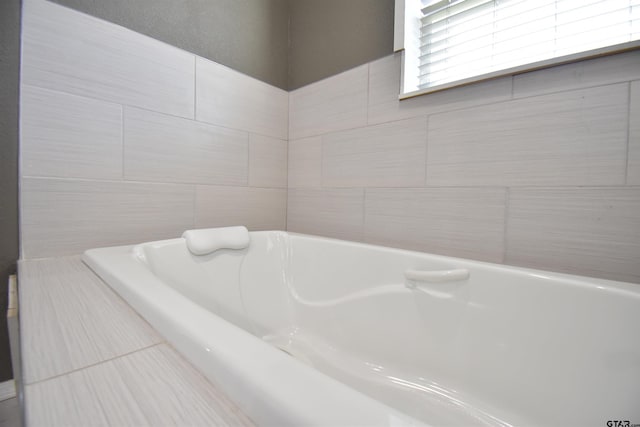 full bathroom featuring a washtub and tile walls