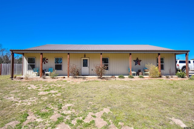 ranch-style house with metal roof, a porch, and a front yard