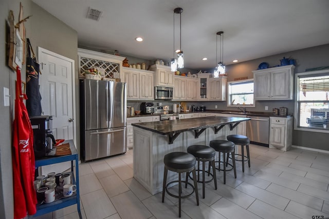 kitchen featuring visible vents, a kitchen breakfast bar, appliances with stainless steel finishes, a center island, and pendant lighting