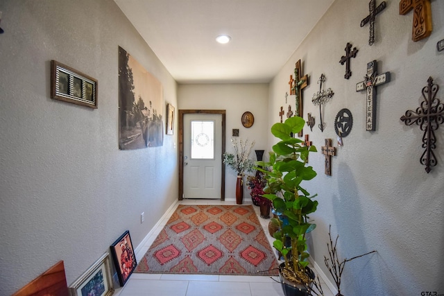 doorway to outside with baseboards and tile patterned floors