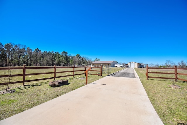 view of street with driveway and a rural view