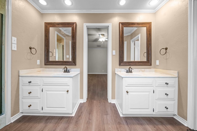 5806 Plantation Dr, Tyler, TX 75703 - bathroom featuring crown molding, wood finished floors, two vanities, baseboards, and a ceiling fan