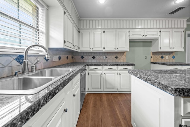 5806 Plantation Dr, Tyler, TX 75703 - kitchen with a sink, dishwasher, dark countertops, white cabinets, and backsplash