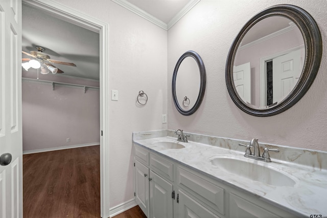 5806 Plantation Dr, Tyler, TX 75703 - bathroom with wood finished floors, crown molding, double vanity, a ceiling fan, and a textured wall