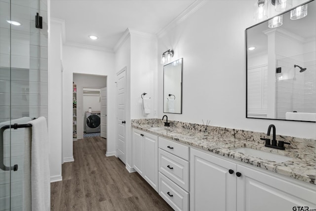 2736 Royal Village Way, Tyler, TX 75701 - bathroom with crown molding, a shower stall, washer / clothes dryer, double vanity, and wood finished floors