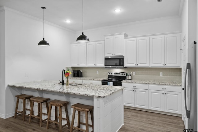 2736 Royal Village Way, Tyler, TX 75701 - kitchen with stainless steel microwave, electric range, white cabinetry, ornamental molding, and recessed lighting