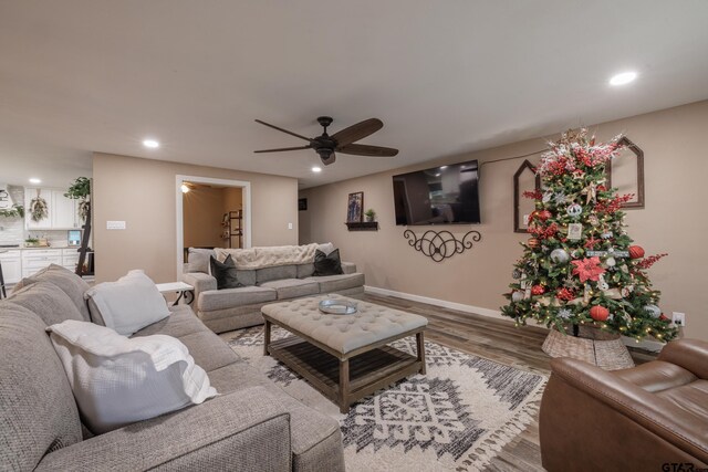 living room with ceiling fan and light wood-type flooring