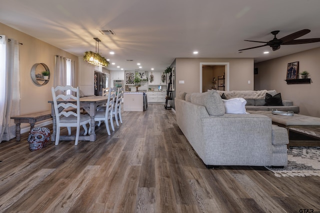 living room featuring ceiling fan and dark hardwood / wood-style flooring