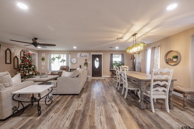 living room with hardwood / wood-style flooring, plenty of natural light, and ceiling fan with notable chandelier