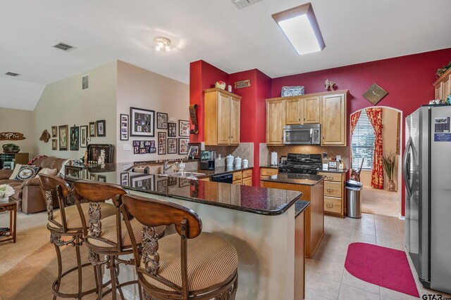9196 Teal Flight Way, Tyler, TX 75703 - kitchen featuring a peninsula, stainless steel appliances, tasteful backsplash, light tile patterned flooring, and visible vents