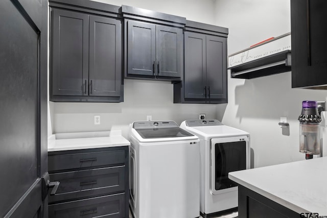 clothes washing area with washer and clothes dryer and cabinets