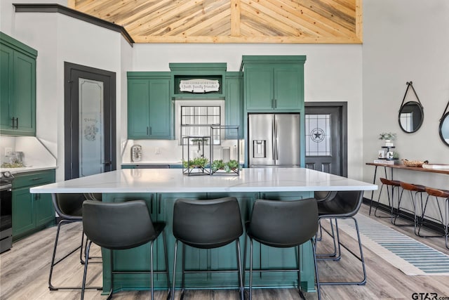 kitchen with wooden ceiling, green cabinetry, a kitchen island, appliances with stainless steel finishes, and light hardwood / wood-style floors