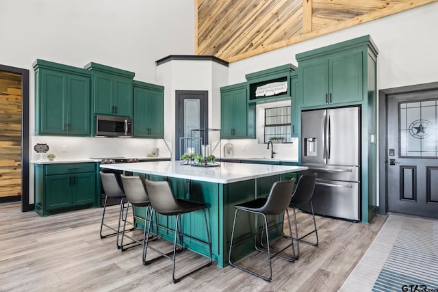 kitchen featuring a breakfast bar, wooden ceiling, high vaulted ceiling, green cabinetry, and appliances with stainless steel finishes