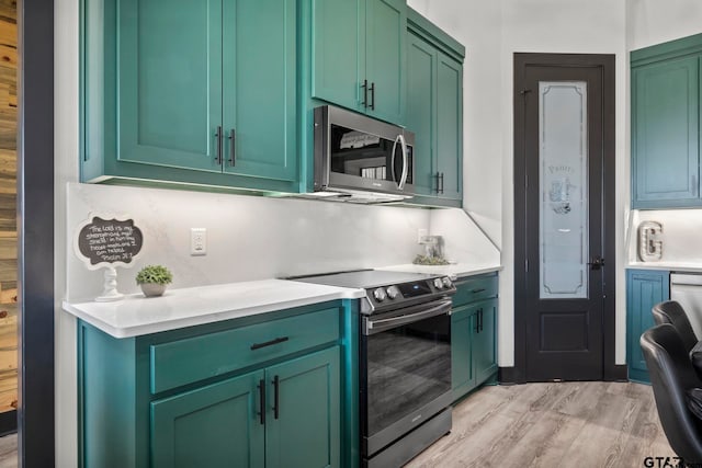 kitchen with green cabinets, decorative backsplash, light hardwood / wood-style floors, and appliances with stainless steel finishes