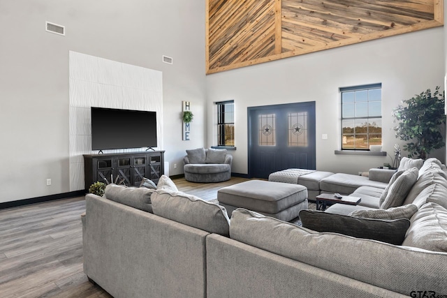 living room featuring a high ceiling, wooden ceiling, and wood-type flooring