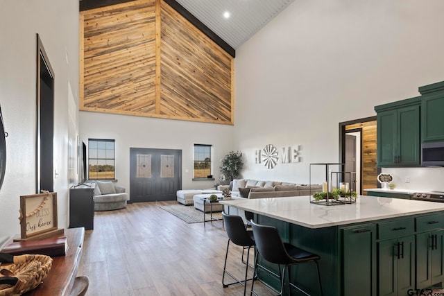 kitchen featuring plenty of natural light, light hardwood / wood-style flooring, high vaulted ceiling, and green cabinetry