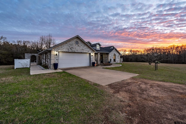 view of front of property featuring a garage and a lawn