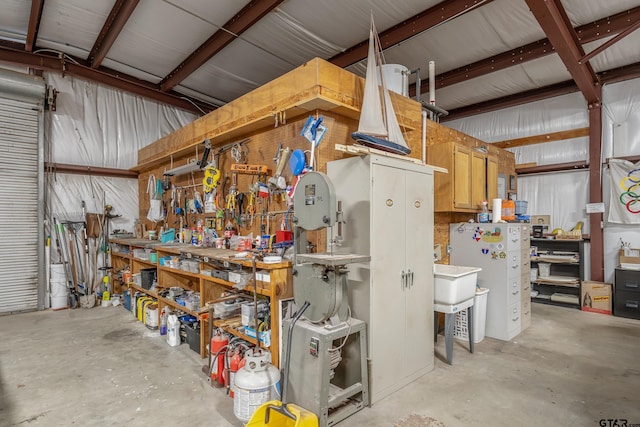 garage featuring a workshop area and white refrigerator