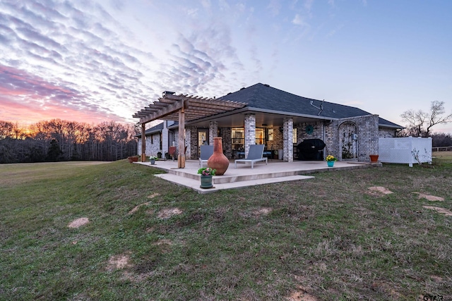 back house at dusk featuring a pergola, a yard, and a patio