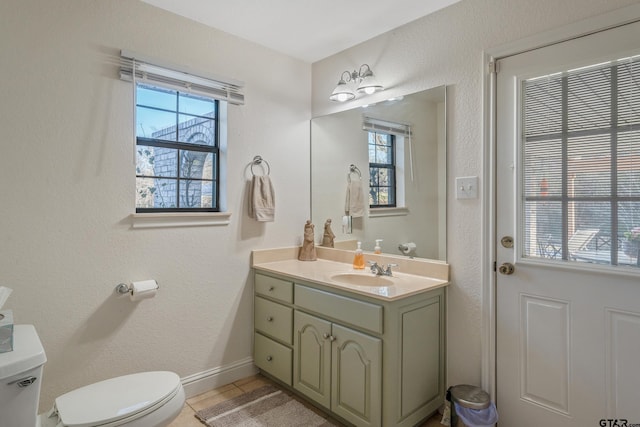 bathroom with tile patterned flooring, vanity, and toilet