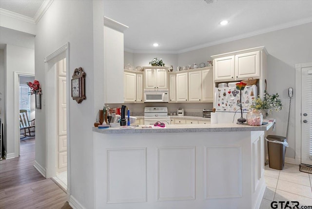 kitchen featuring white cabinetry, kitchen peninsula, light wood-type flooring, white appliances, and ornamental molding