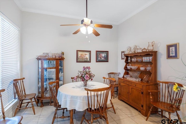 tiled dining room with ceiling fan and ornamental molding