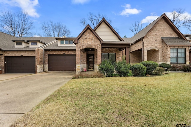 view of front of home with a front yard, brick siding, driveway, and roof with shingles