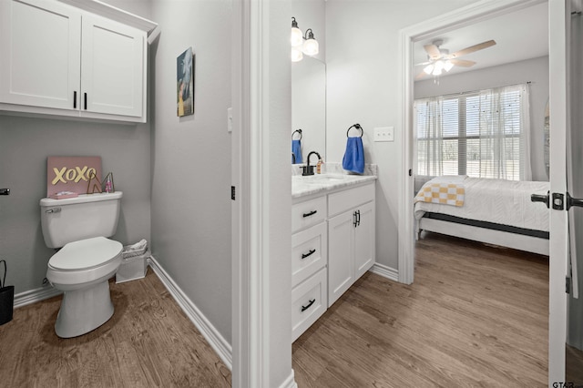 bathroom with ceiling fan, hardwood / wood-style floors, vanity, and toilet