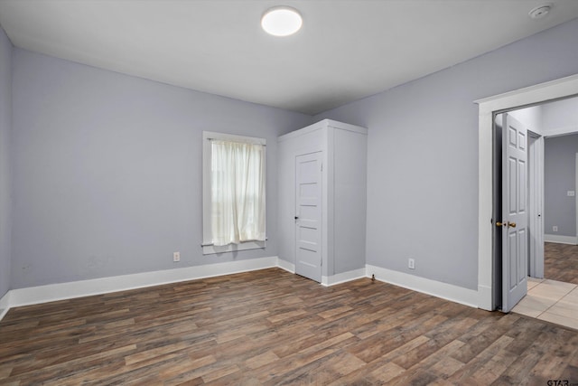 unfurnished bedroom with baseboards and wood finished floors