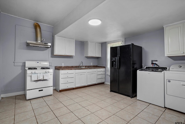 kitchen with dark countertops, black fridge, baseboards, white range with gas stovetop, and washer and clothes dryer