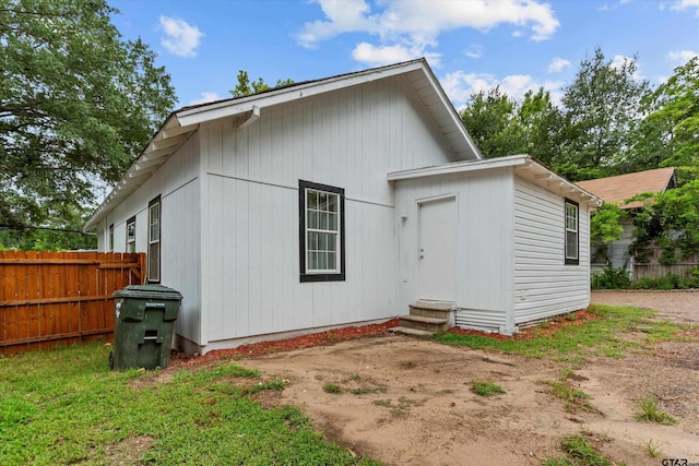 back of property featuring fence and entry steps