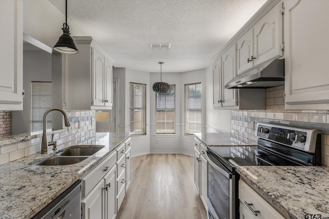 kitchen featuring sink, white cabinets, decorative light fixtures, and appliances with stainless steel finishes