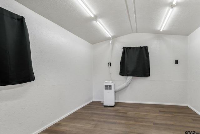 bathroom featuring wood-type flooring and vaulted ceiling