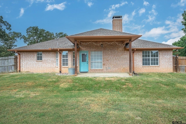 back of house featuring a patio area and a lawn