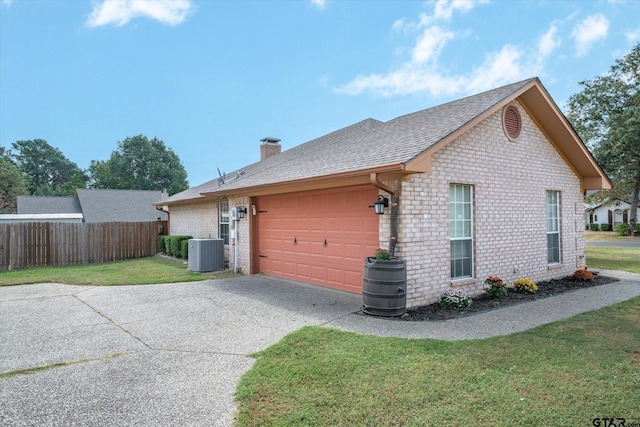 view of side of property with central AC unit, a garage, and a lawn