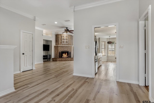 living room with ceiling fan, light hardwood / wood-style floors, ornamental molding, and a fireplace