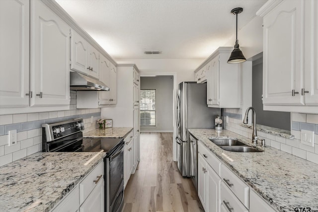 kitchen featuring white cabinets, stainless steel appliances, hanging light fixtures, and sink