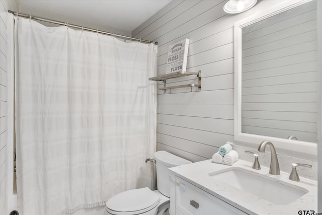 bathroom featuring vanity, toilet, walk in shower, and wood walls