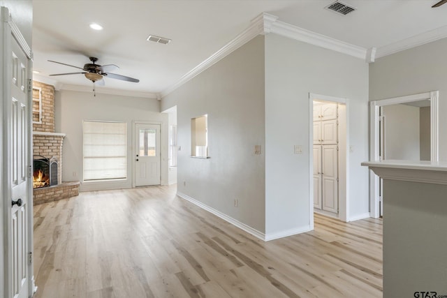 unfurnished living room with a fireplace, light hardwood / wood-style floors, ceiling fan, and crown molding