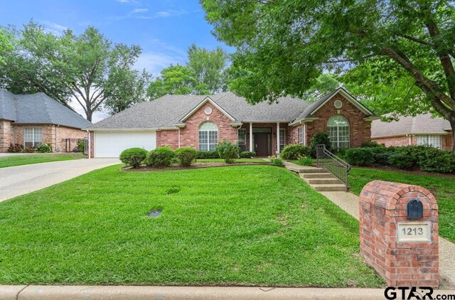1213 Parkview Dr, Tyler, TX 75703 - ranch-style home with a garage, brick siding, roof with shingles, and a front lawn