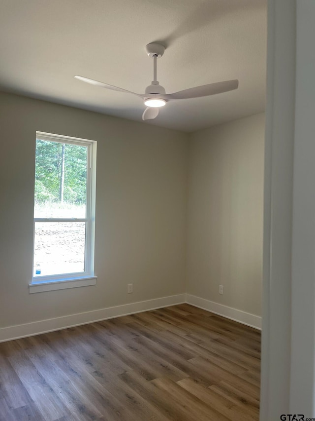 empty room with dark hardwood / wood-style floors and ceiling fan