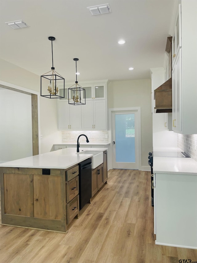 kitchen with dishwasher, sink, light hardwood / wood-style floors, and white cabinets