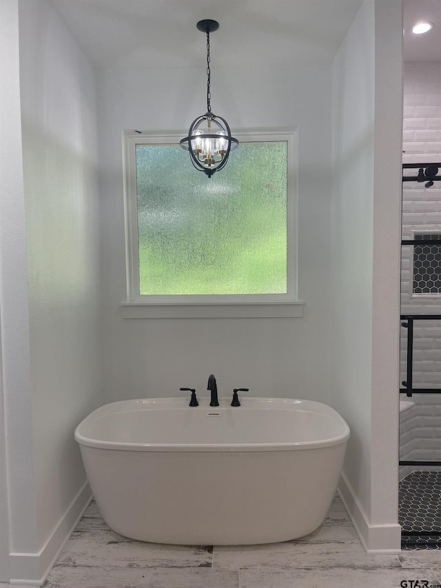 bathroom with a chandelier and a bathing tub