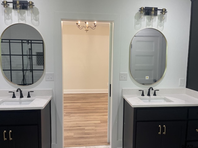 bathroom with wood-type flooring, vanity, and a notable chandelier